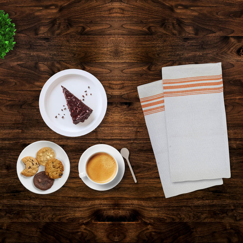 Folded striped napkins beside desserts and coffee on a wooden table