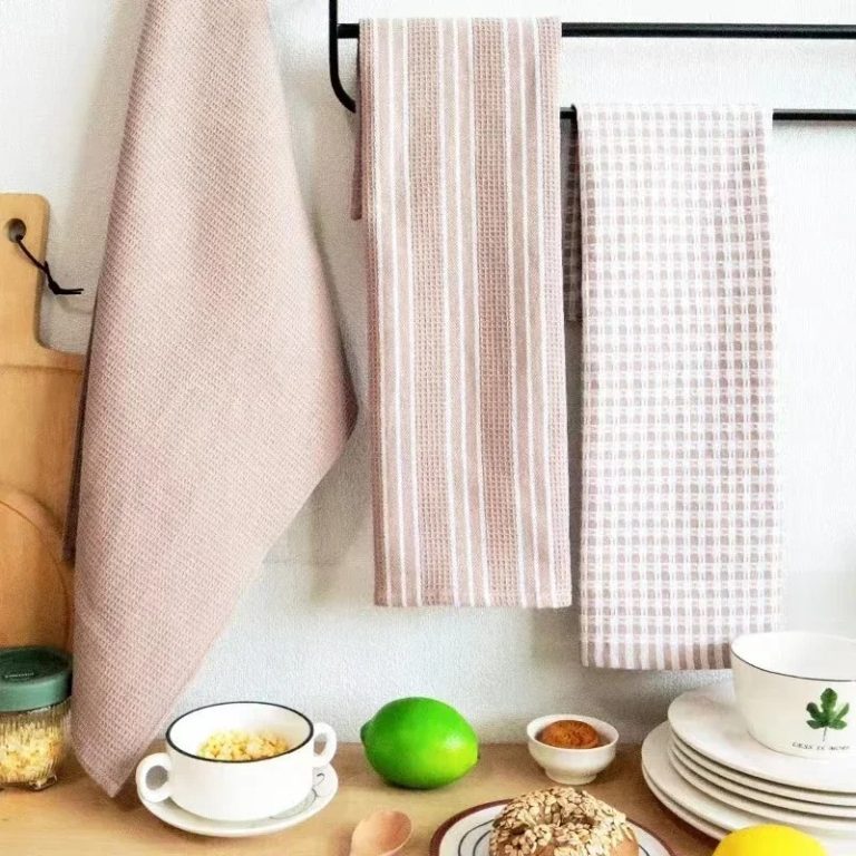 Waffle and gingham kitchen towels hanging on a rail