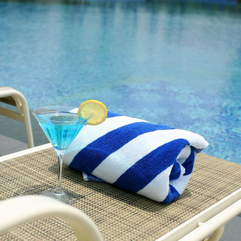 Rolled blue striped pool towel on a sun lounger